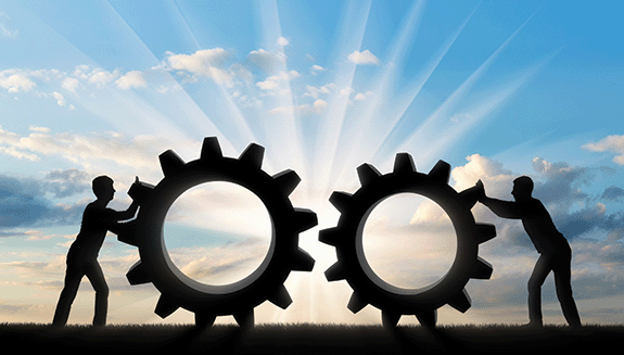 1660316669609 Silhouetteofmenpushinglargegearsoverland