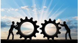 silhouette-of-men-pushing-large-gears-over-land