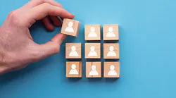 hand-placing-final-block-in-3-by-3-square-made-of-wood-blocks-with-icons-of-people