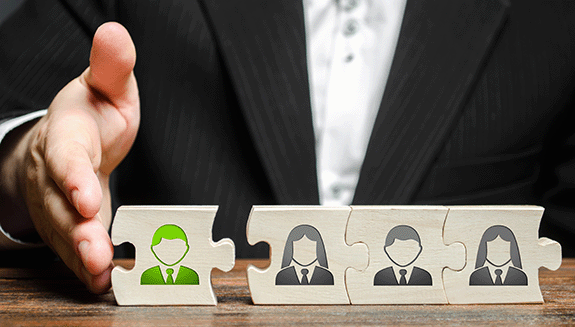 1663606670247 Businesspersonpushingtogetherpuzzleblockswithiconsofemployeesandanewemploye