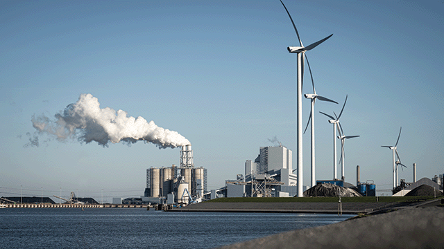 image of factory surrounded by windmills