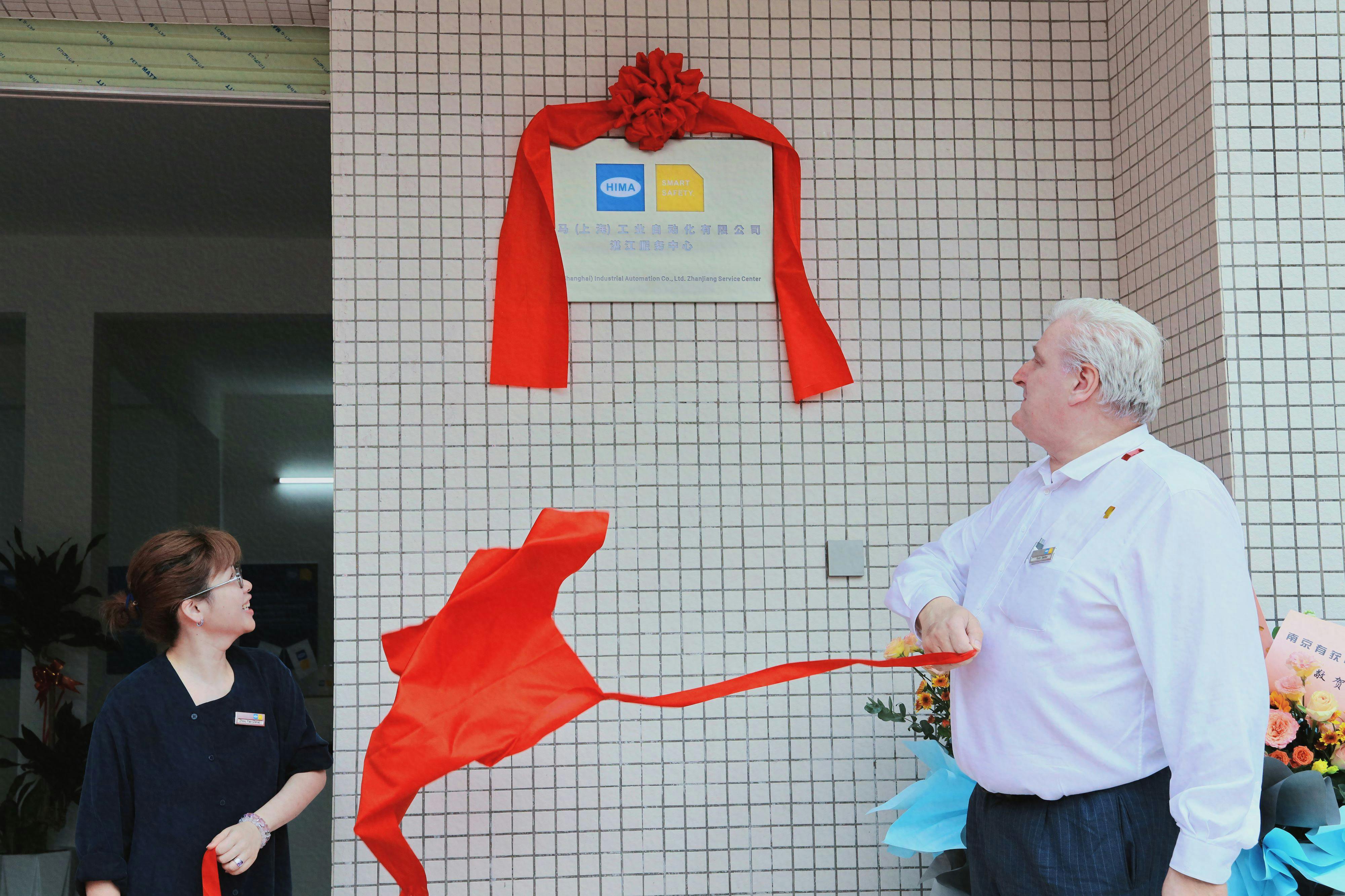 Yao Zhou, managing director at HIMA China (left), and Peter Sieber, strategic marketing VP at HIMA Group, unveil the nameplate at the May 31 opening of the HIMA China Zhanjiang Service Center.