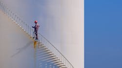 Engineer is walking up spiral staircase to working on top of fuel tank Engineer is walking up spiral staircase to working on top of fuel tank