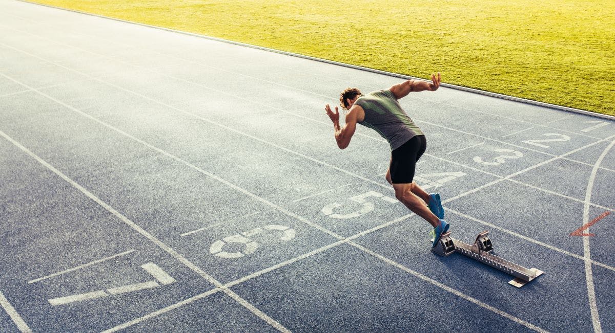 Rear view of an athlete starting his sprint on an all-weather running track