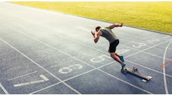 Rear view of an athlete starting his sprint on an all-weather running track Rear view of an athlete starting his sprint on an all-weather running track