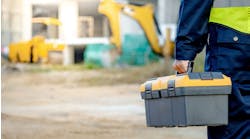 Construction worker man in protective suit and reflective green vest standing with building structure in the background Construction worker man in protective suit and reflective green vest standing with building structure in the background
