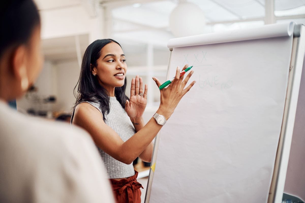 Woman, mentor and whiteboard in office for training, teaching and learning for skill or career development