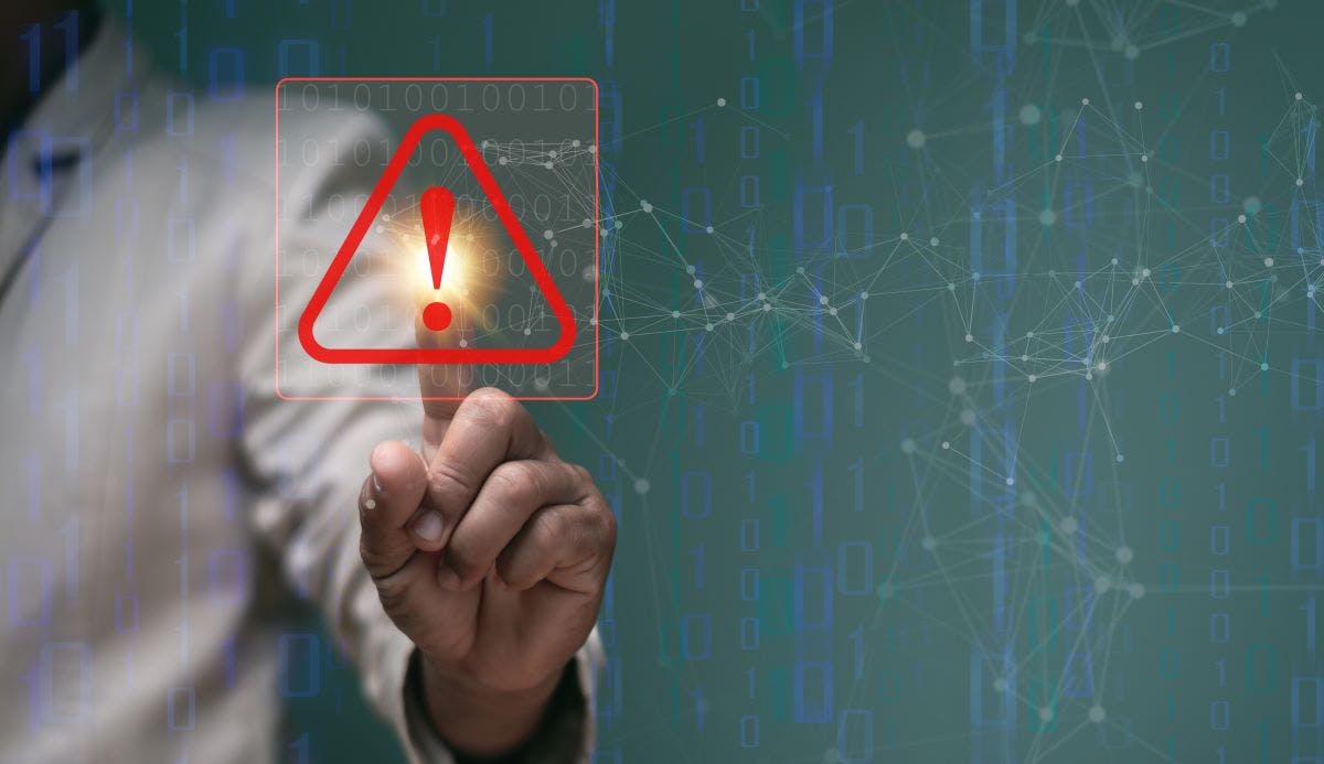 Businessman pointing to triangle caution warning sign for notification error and maintenance concept