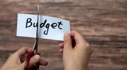 Scissors cutting word budget on paper Scissors cutting word budget on paper