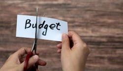 Scissors cutting word budget on paper Scissors cutting word budget on paper