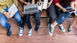 Young men and women sitting relaxed use tablet ,computer notebook on a wooden bench in college.Students using technology to learn the lessons of the student group during semester Young men and women sitting relaxed use tablet ,computer notebook on a wooden bench in college.Students using technology to learn the lessons of the student group during semester