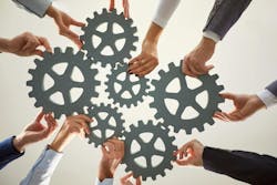Hands from diverse individuals work together to arrange large gears on a surface, symbolizing cooperation and collective effort for success in a business environment. Hands from diverse individuals work together to arrange large gears on a surface, symbolizing cooperation and collective effort for success in a business environment.