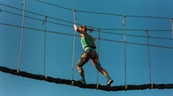 Skilled adult woman racing through the difficult course in the adventure park with ease Skilled adult woman racing through the difficult course in the adventure park with ease