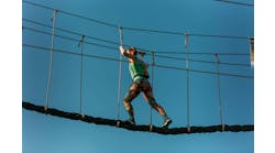 Skilled adult woman racing through the difficult course in the adventure park with ease Skilled adult woman racing through the difficult course in the adventure park with ease