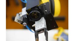 A robot in a factory equipped with a machine vision camera. A robot in a factory equipped with a machine vision camera.