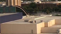 Though hard to see when not moving, a technician on the roof of San Antonio’s convention center services some equipment in the field. Though hard to see when not moving, a technician on the roof of San Antonio’s convention center services some equipment in the field.