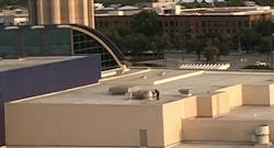 Though hard to see when not moving, a technician on the roof of San Antonio’s convention center services some equipment in the field. Though hard to see when not moving, a technician on the roof of San Antonio’s convention center services some equipment in the field.