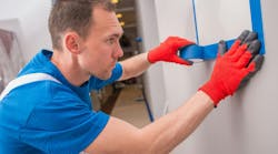 Preparing Walls and Electric Elements For Room Painting by Covering by Blue Paint Tape. Preparing Walls and Electric Elements For Room Painting by Covering by Blue Paint Tape.