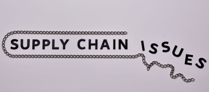 Supply Chain issues concept. Black letters with steel chain.