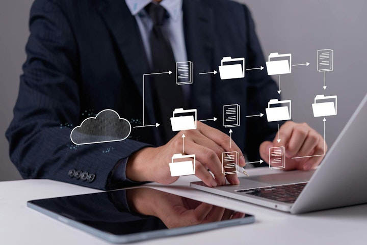 Professional managing digital documents and data flow on laptop, symbolizing cloud computing, organized file management, and efficient digital transformation for business.