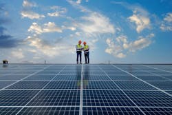 Engineers walking on roof inspect and check solar cell panel by holding equipment box and radio communication Engineers walking on roof inspect and check solar cell panel by holding equipment box and radio communication