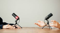 Two women in local broadcat studio recording audio podcast. Sitting opposite each other, hands close-up Two women in local broadcat studio recording audio podcast. Sitting opposite each other, hands close-up