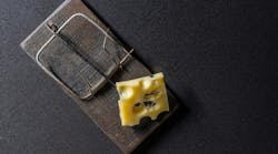 Wooden mousetrap with a piece of yellow cheese on a dark background, close up, top view. Wooden mousetrap with a piece of yellow cheese on a dark background, close up, top view.