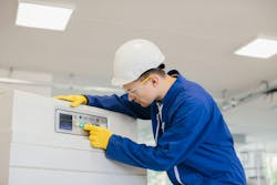 Industrial technician operating control panel, pushing button, wearing safety glasses, gloves, and helmet Industrial technician operating control panel, pushing button, wearing safety glasses, gloves, and helmet