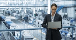 Electronics Manufacturing Technician Working on a Laptop Computer at a Factory Space. Female Specialist Developing, Maintaining, Upgrading Programs for Machine Production and Assembly Electronics Manufacturing Technician Working on a Laptop Computer at a Factory Space. Female Specialist Developing, Maintaining, Upgrading Programs for Machine Production and Assembly