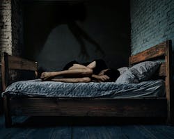 This image captures the chilling essence of sleep paralysis: a person curled in fear, with a shadowy hand looming overhead, symbolizing the helplessness and terror of the experience. This image captures the chilling essence of sleep paralysis: a person curled in fear, with a shadowy hand looming overhead, symbolizing the helplessness and terror of the experience.