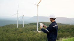 Engineer Monitoring Wind Turbine with Tablet: Technology and Efficiency in Renewable Energy. Business and Environmental Responsibility Engineer Monitoring Wind Turbine with Tablet: Technology and Efficiency in Renewable Energy. Business and Environmental Responsibility
