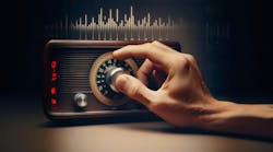 Hand tuning an old-style radio knob on a dark background Hand tuning an old-style radio knob on a dark background