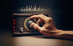 Hand tuning an old-style radio knob on a dark background Hand tuning an old-style radio knob on a dark background
