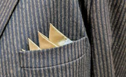 satin pocket square is tucked into a pin stripe suit coat pocket. photo is closeup. satin pocket square is tucked into a pin stripe suit coat pocket. photo is closeup.