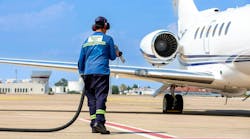 Technician refueling private jet with sustainable aviation fuel at the airport. Technician refueling private jet with sustainable aviation fuel at the airport.