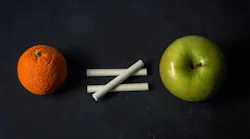 Orange does not equal apple with chalk on top of chalkboard suggesting inequality in different fruit