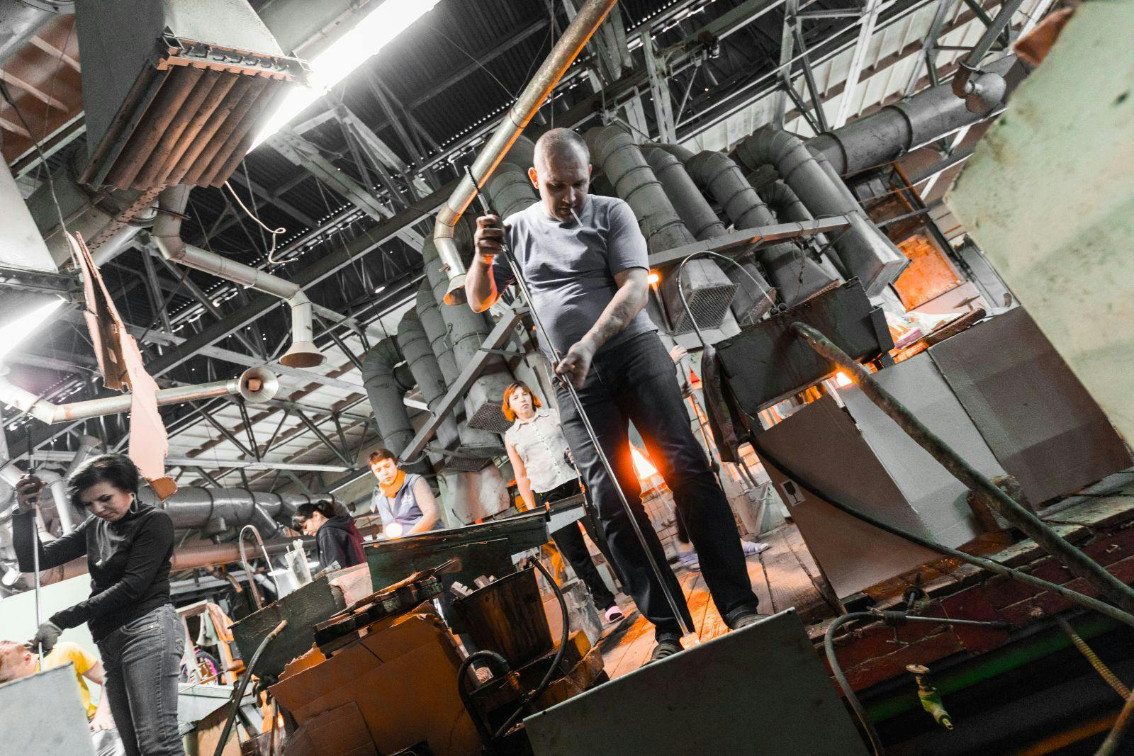 Glass factory workers on production of glass background working with manufacture equipment.