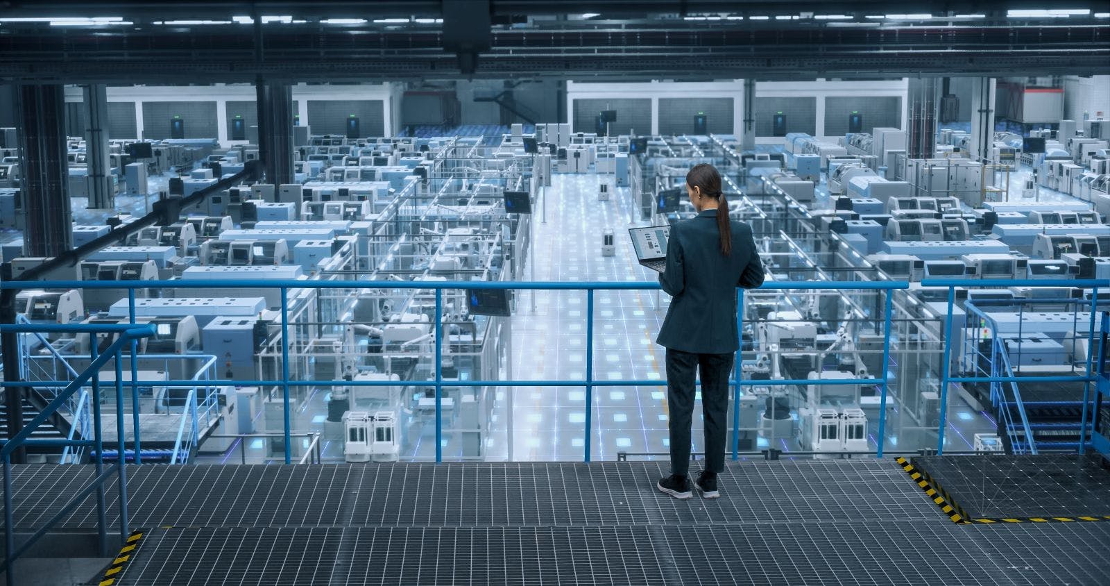 Female Engineer Uses Laptop to Activate Construction of Autonomous Robot Arm Industrial Facility.