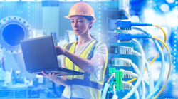 Industrial network engineer configures equipment with laptop, monitoring data connections, managing control systems, ensuring reliable automation, cybersecurity, and plant operations.