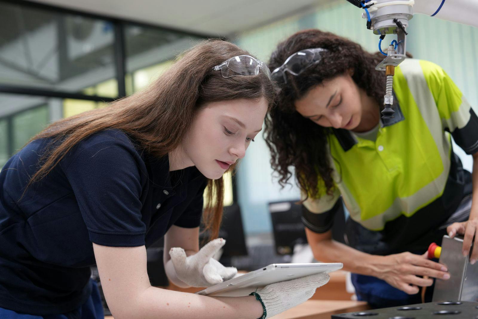 Two female engineers learn programming software for automated manufacturing technology and for use in the manufacturing industry and provides programming services for robotic welding machines
