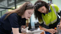Two female engineers learn programming software for automated manufacturing technology and for use in the manufacturing industry and provides programming services for robotic welding machines