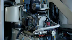 A detailed close up of a compressor machine featuring two gauges situated on it