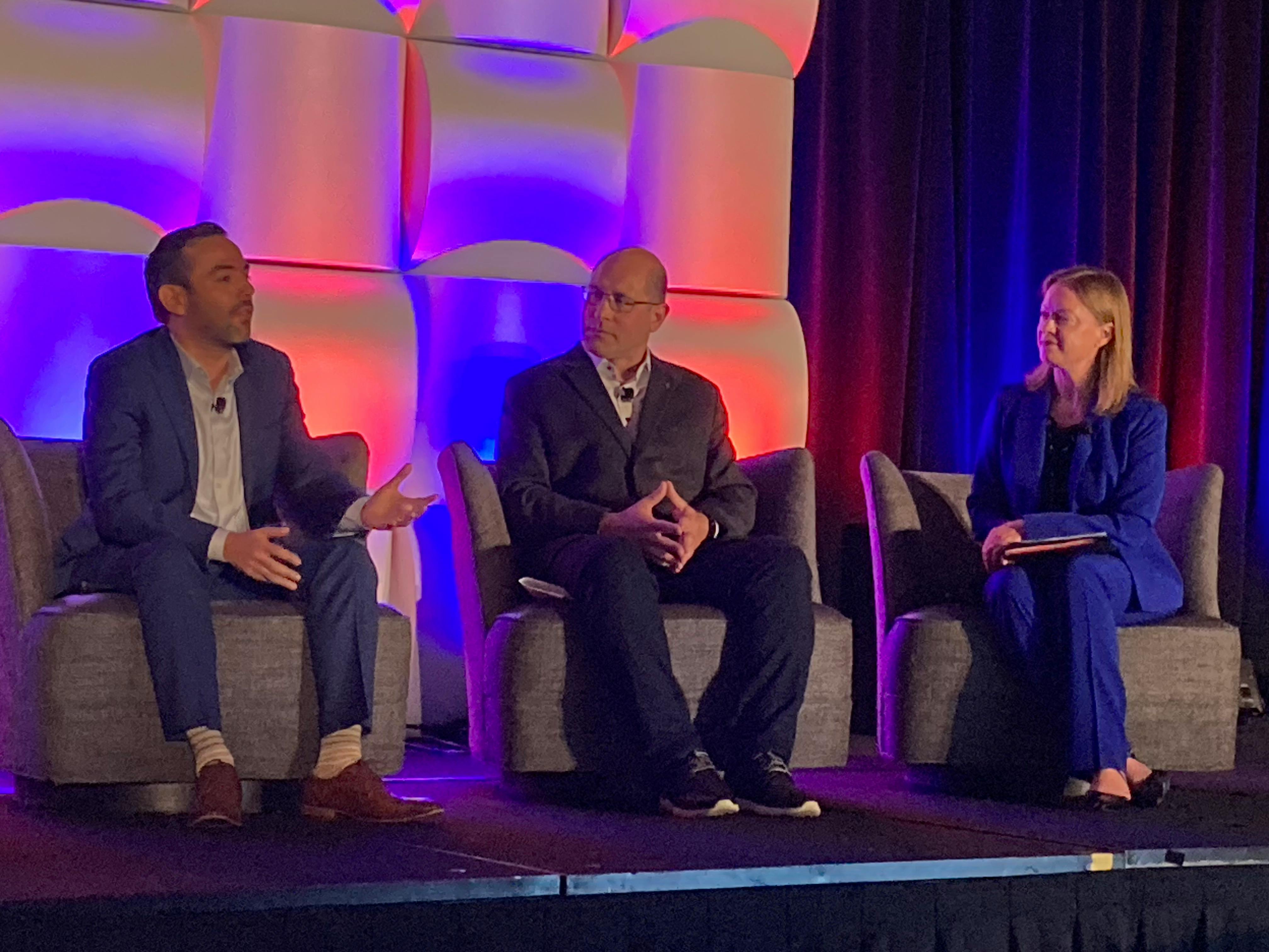 Daniel Gomez, CEO of Omnicon (left), makes a point to Jeremy Anderson, president of Process & Data Automation (center), and Adrienne Mayer, CEO of CSIA (right) during the May 6 opening panel at CSIA&rsquo;s 2026 conference in Baltimore.