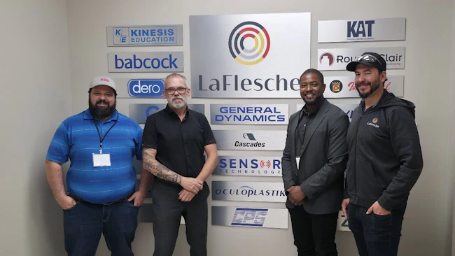 ABB and LaFlesche employees standing in front of a wall of channel-partner collaborators.