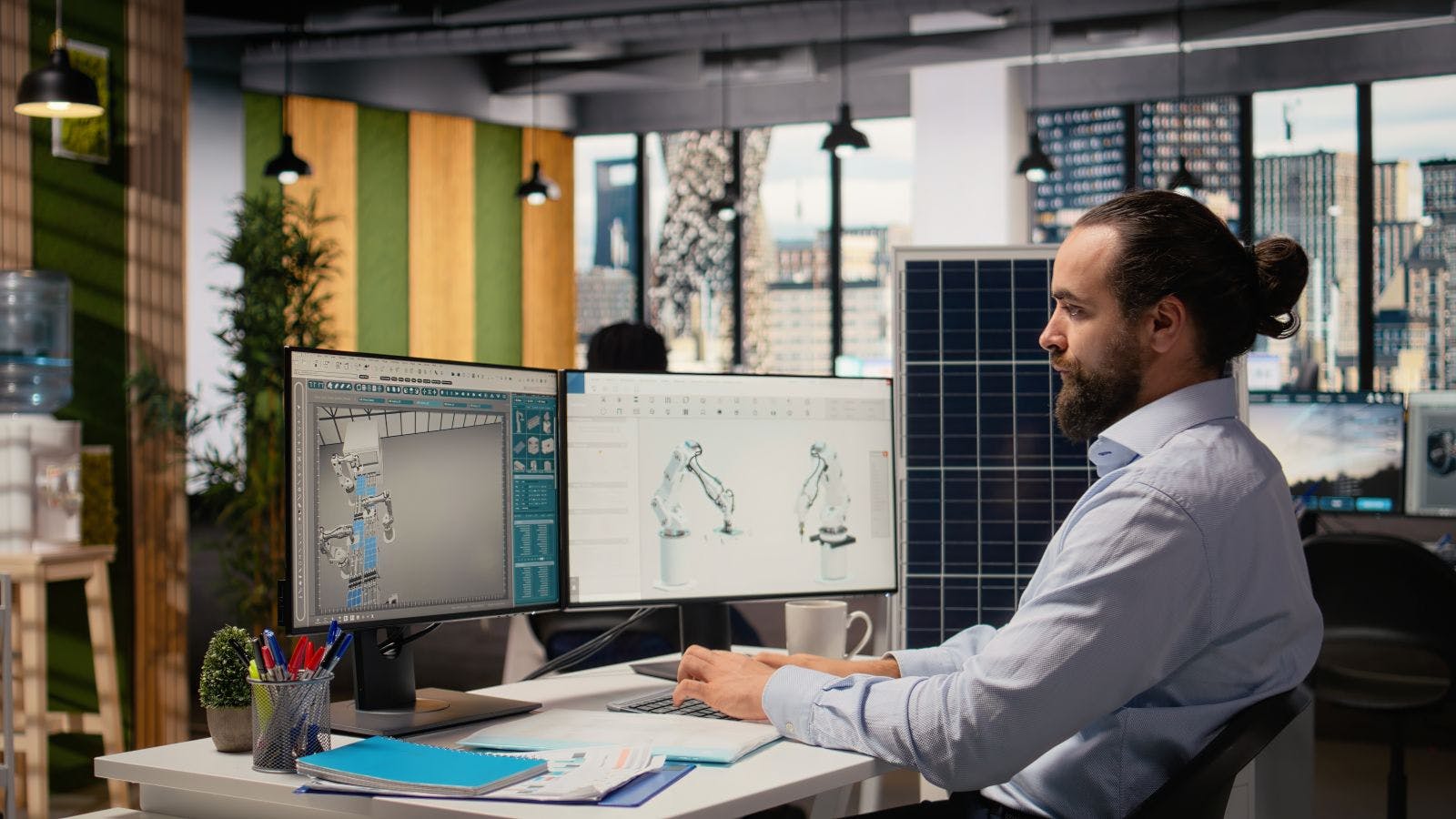 Sustainability RD expert uses CAD program on PC to design production lines for solar panel assembly.