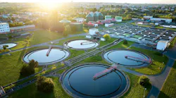 Aerial view of wastewater treatment plant at sunrise, ideal for illustrating sustainable water management, environmental engineering, and modern infrastructure in urban planning contexts.