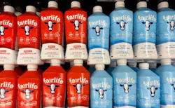 Fairlife milk bottles in red and blue packaging in store refrigerator.