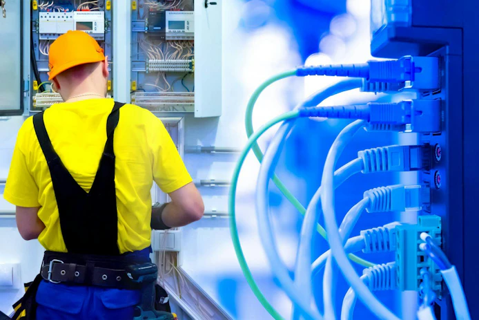 Energy consumption system in the office. The electrician mounts the shield and lays the wires. Installation of the electricity supply system. Block for connecting devices to the electrical network.