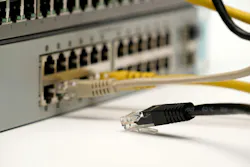 Close-up of a disconnected Ethernet cable lying near active ports of a network switch, symbolizing internet failure, IT troubleshooting, and connectivity issues.