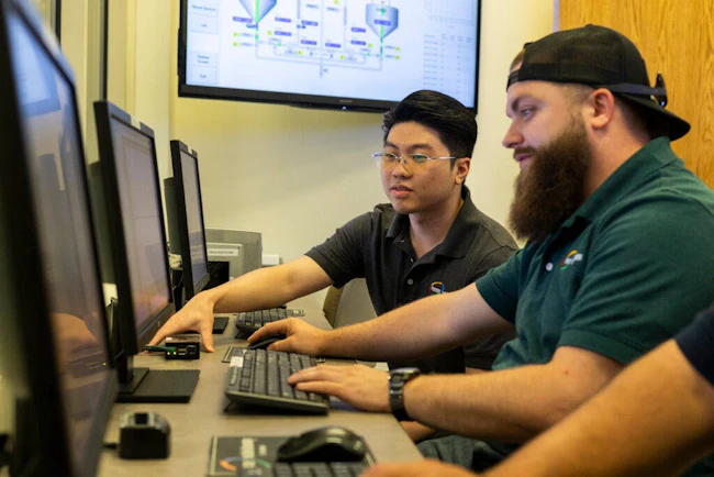 Two Process and Data Automation employees working together on computers